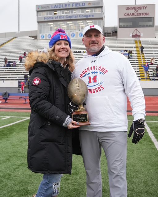 woman-man-holding-football-trophy