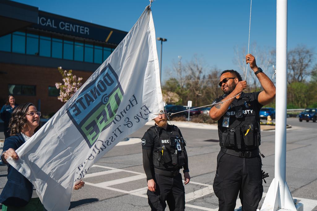 A security guard assists in raising a Donate Life flag at Berkeley Medical Center in April 2026.