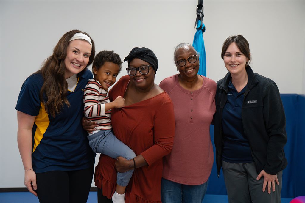 WVU Medicine speech and occupational therapists pose for a photo with Oaklee and his mother and grandmother during a recent therapy session.