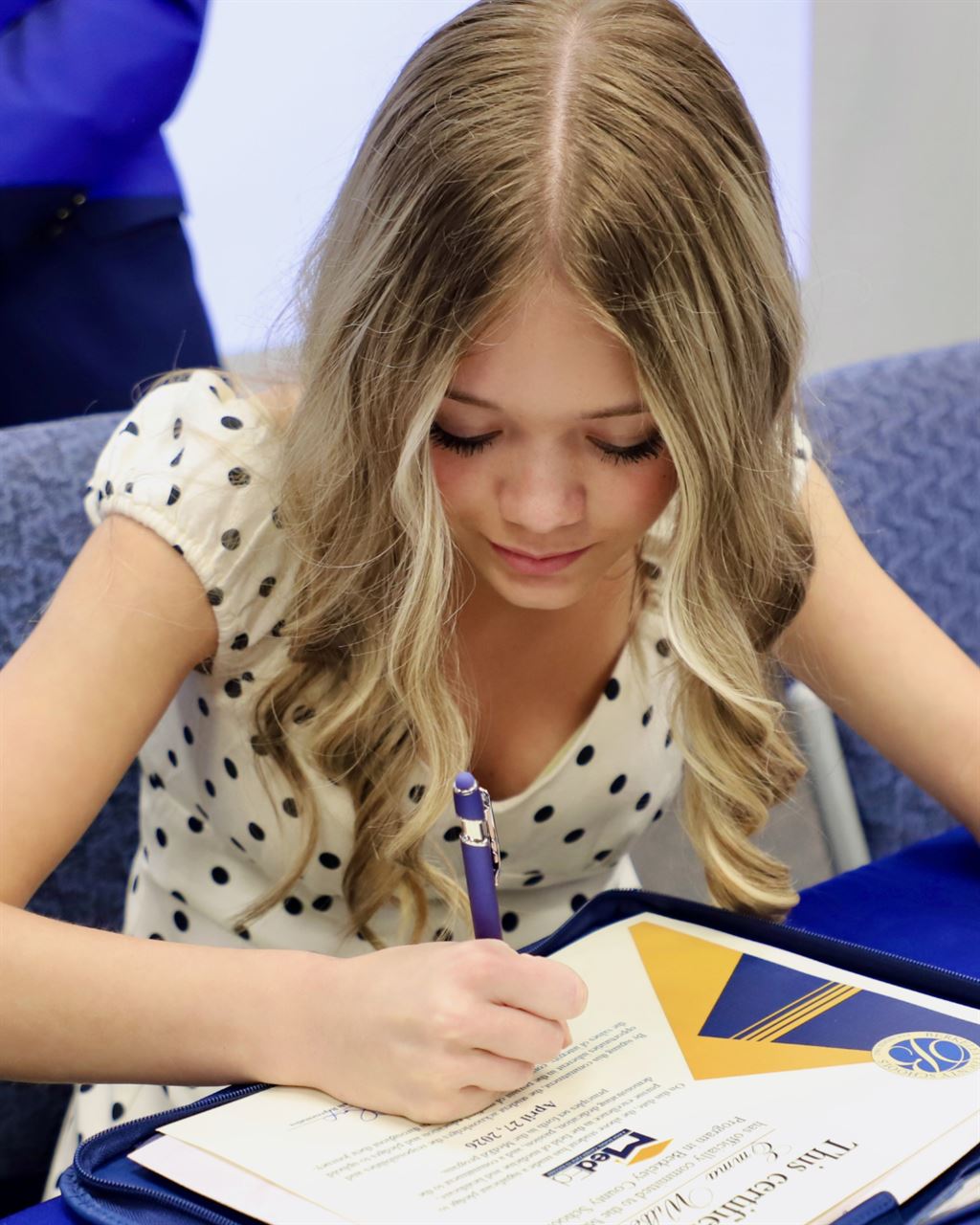 Emma Wilber signs her MedEd Program Certificate.