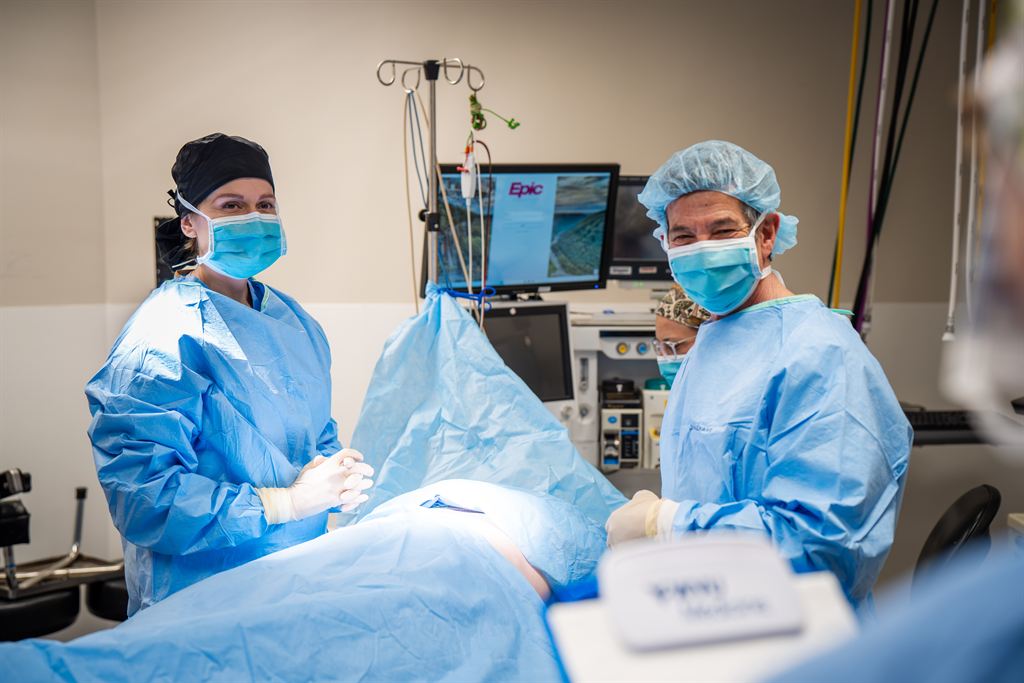 Dr. Jack Gelman and Sarah Cross, PA-C, don scrubs in a WVU Medicine operating room.
