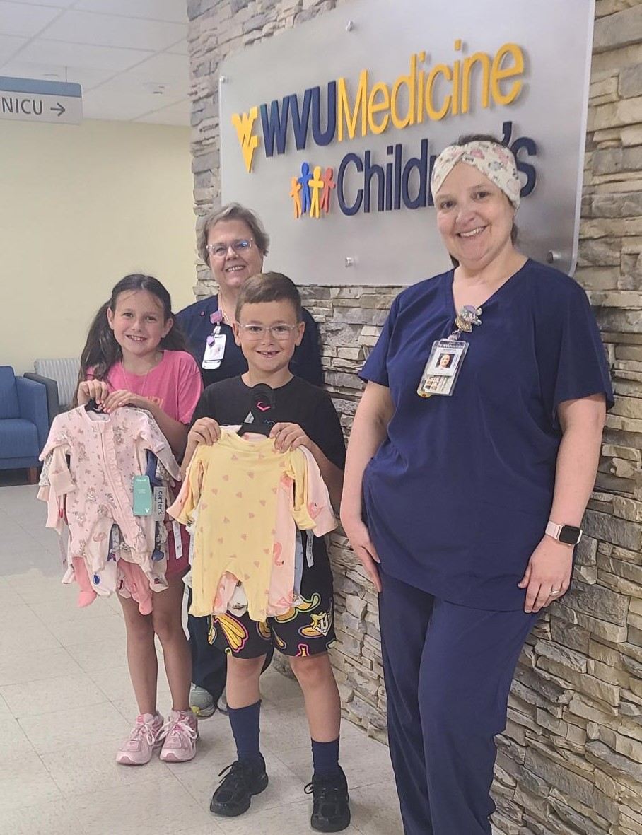 The Omerzo children pose for a photo at WVU Medicine Berkeley Medical Center with their donations and providers.