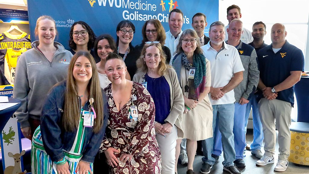 group-of-people-in-front-of-blue-sign