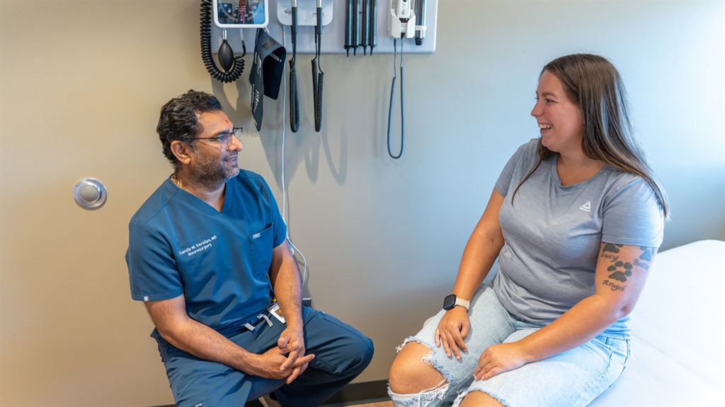 Dr. Sandip Savaliya speaks with a patient, ChyAnn, after a pain-relieving herniated disc procedure.