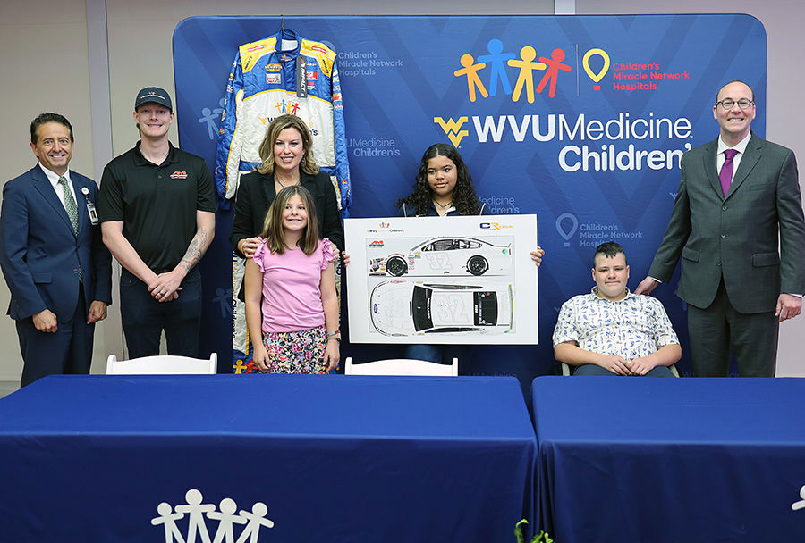 Photo identifications (from left to right): Michael&nbsp; Grace, Ed.D., M.B.A., F.A.C.H.E., president of WVU Hospitals;&nbsp; AM Racing&rsquo;s Christian Rose; Amy L. Bush, B.S.N., M.B.A., R.N., C.N.O.R., chief administrative officer for WVU Medicine Children's; patients Addison Schrock, Ivy Martin, and Brantly&nbsp; Poling; and Albert L. Wright, Jr., president and CEO of the&nbsp; West Virginia University Health System&nbsp;
