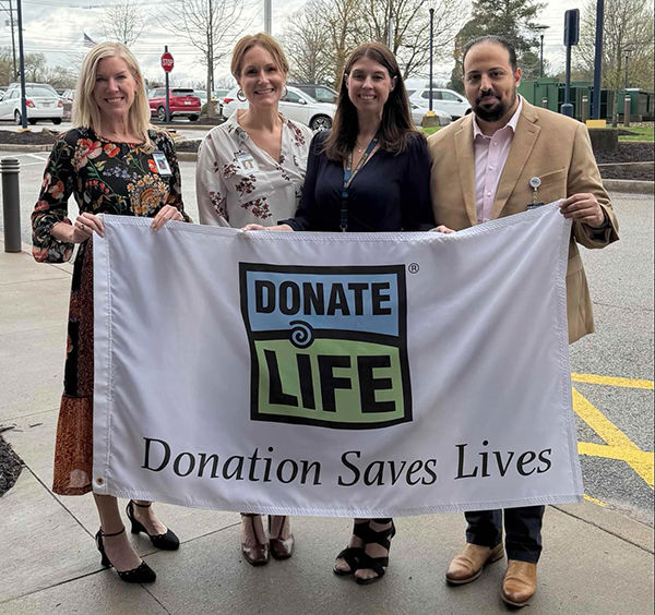 Uniontown Hospital leadership pose with Donate Life Month flag at CORE flag raising cermeony.
