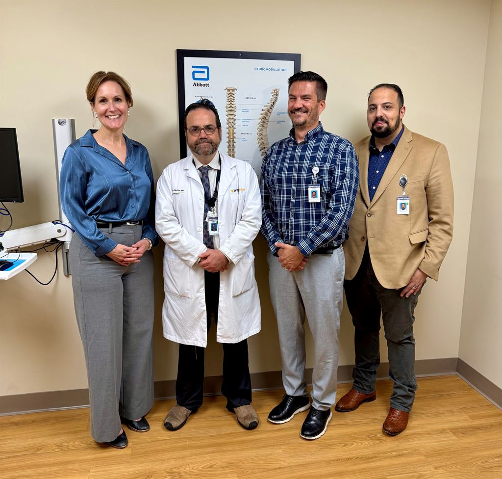 Colleagues stand for photo in clinical exam room